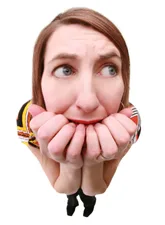 A girl displaying visible signs of fear, with wide eyes and tense posture, illustrating the experience of intense anxiety.